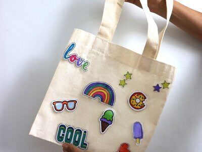 Child holding a canvas tote bag decorated with patches – Tote-ally UAE: Tote Design Lab